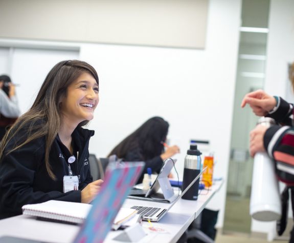 students smiling at desk